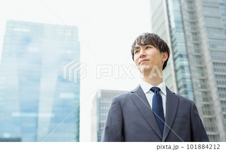 ビジネス街で真剣な表情で遠くを眺める20代から30代のスーツ姿の男性 101884212