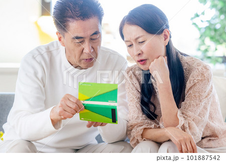 年金手帳を見るシニアの夫婦 年金手帳を見るシニアの夫婦 101887542