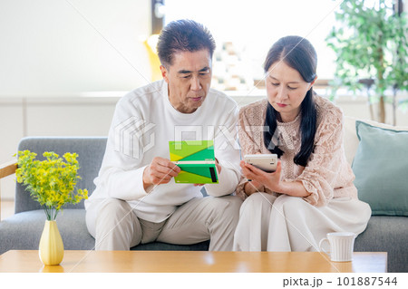 年金手帳を見るシニアの夫婦 101887544