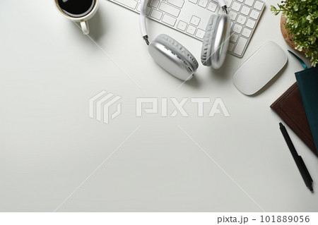 Flat lay, top view of wireless headphone, cup of coffee and keyboard on white office desk. Copy space for your text Flat lay, top view of wireless headphone, cup of coffee and keyboard on white office desk. Copy space for your text 101889056