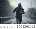 athlete runner in grey sports jacket forest trail in the rain 101890112