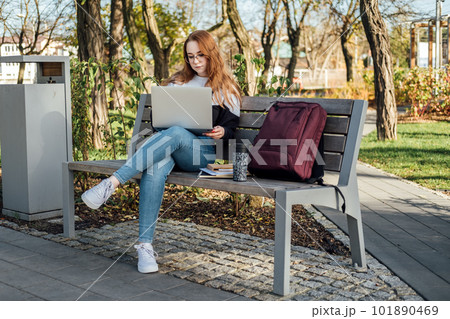 Artificial Intelligence AI in education industry. Applications of Artificial Intelligence and chatbots in Education. Student girl with laptop using chatbot for studying process 101890469