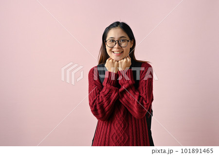 Cute and shy young Asian female college student in a red knitted sweater and glasses Cute and shy young Asian female college student in a red knitted sweater and glasses 101891465