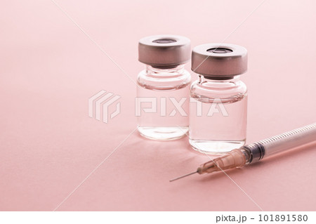 ピンクの背景に注射器とバイアルのメディカルイメージ素材 101891580