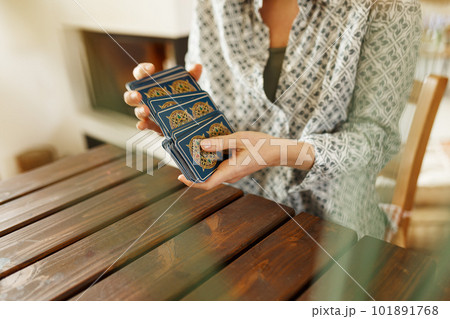 Fortune teller with tarot cards on table near burning candle.Tarot cards spread on table with magic herbs and palo santo aroma sticks. Forecasting concept 101891768