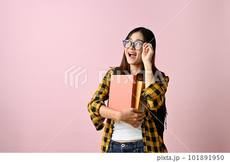 Wise Asian female college student touching her glasses, showing amazed facial expression 101891950