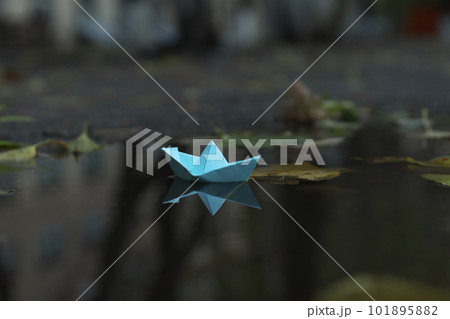 Paper boat in puddle outdoor in rainy weather 101895882