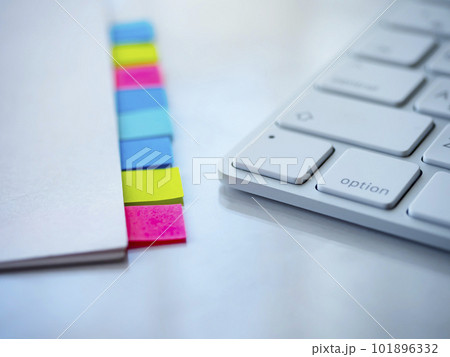 テーブルに置かれた付箋の付いた書類とキーボード 101896332