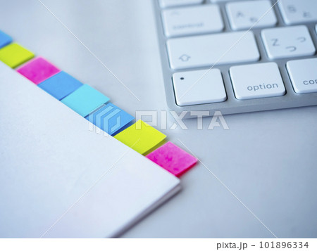 テーブルに置かれた付箋の付いた書類とキーボード 101896334