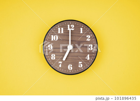 The Retro wooden clock at 7 O' clock on yellow color background. 101896435