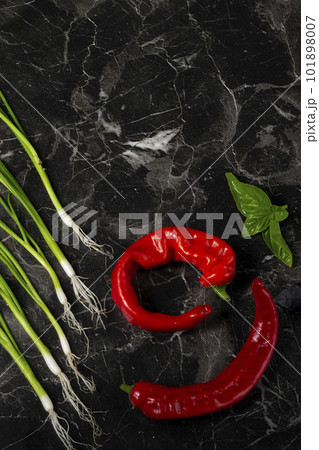 Vegetables for salad on a gray background. Red hot peppers and onions, lemon. Still life of bright vegetables 101898007