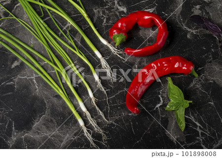 Vegetables for salad on a gray background. Red hot peppers and onions, lemon. Still life of bright vegetables Vegetables for salad on a gray background. Red hot peppers and onions, lemon. Still life of bright vegetables 101898008