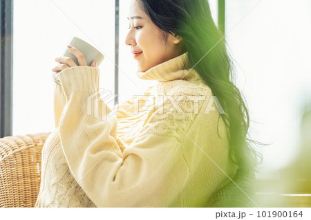 ゆったりコーヒーを飲むニット素材のセーターを着た女性のポートレート ゆったりコーヒーを飲むニット素材のセーターを着た女性のポートレート 101900164