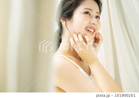 窓際に立つ美しい女性のビューティーポートレート 101900201