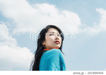 青空の下、遠くを見つめる20代の女性 青空の下、遠くを見つめる20代の女性 101900404