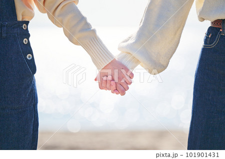 海辺で手をつなぐ仲良しの若い女性と友達 101901431