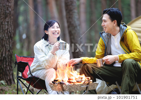 キャンプで焚火をするカップル キャンプで焚火をするカップル 101901751