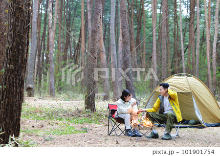 キャンプで焚火をするカップル 101901754