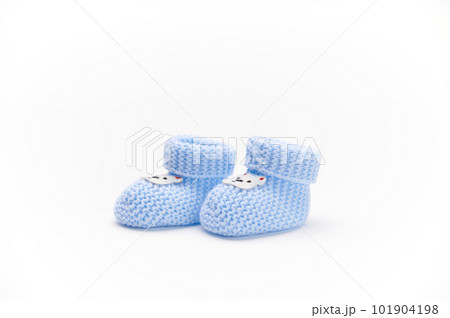 A pair of handmade blue knitted baby booties, isolated on white background. Newborn clothing and pregnancy concept. Copy space for advertising text. Fashion. A pair of handmade blue knitted baby booties, isolated on white background. Newborn clothing and pregnancy concept. Copy space for advertising text. Fashion. 101904198