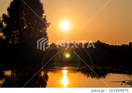 Orange sunny dawn over the water surface of the lake. 101904976