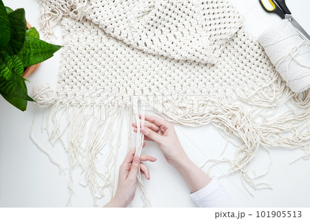 Creative hobby handmade macrame for home decoration. Girl weaves macrame. Woman weaving macrame panels for home decor. Flat lay, top view 101905513