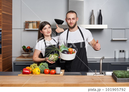 Young couple coocking salad in the kitchen Young couple coocking salad in the kitchen 101905792