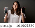 Closeup of funny smiling teen girl showing blank screens of two smart phones holding in hands 101905820