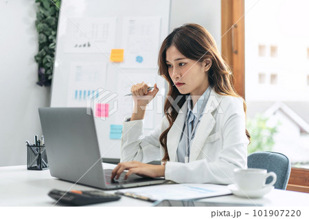 Businesswoman is reading marketing plan report on laptop to anal 101907220