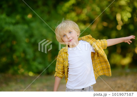 Portrait of cheerful smiling preschooler child during summer holidays on sunny day. Concept of freedom, happy childhood and limitless possibilities. 101907587