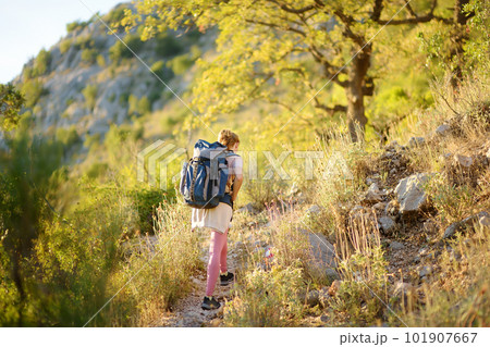 Young woman hiking in countryside. Concepts of adventure, extreme survival, orienteering. Backpacking hike Young woman hiking in countryside. Concepts of adventure, extreme survival, orienteering. Backpacking hike 101907667