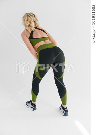 rear view. an blonde in a tracksuit makes inclines on a white background 101911682