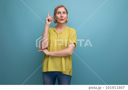 thoughtful mature woman demonstrates knowledge on blue background thoughtful mature woman demonstrates knowledge on blue background 101911807