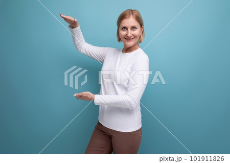 blonde 50s woman in a white sweater demonstrates the size with her hands blonde 50s woman in a white sweater demonstrates the size with her hands 101911826