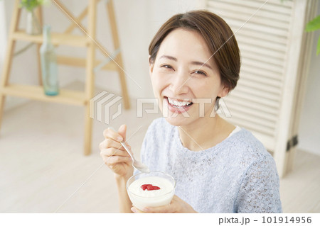 自宅でヨーグルトを食べる女性 カメラ目線 自宅でヨーグルトを食べる女性 カメラ目線 101914956