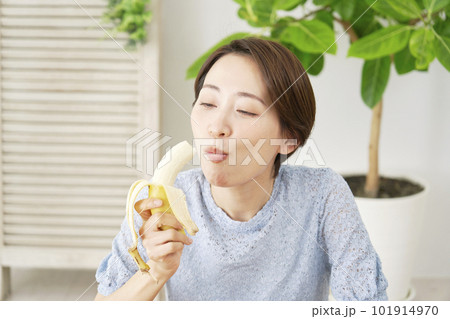 自宅で板ぽバナナを食べる女性 101914970