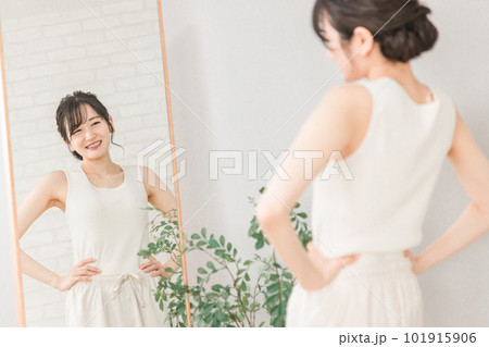 鏡で自分の体型・スタイルをチェックする笑顔のアジア人女性 101915906