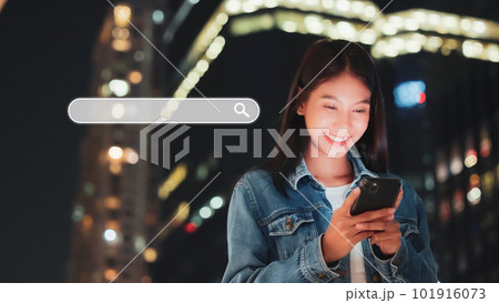 Asian women using smartphones to find what they are interested in city night life 101916073