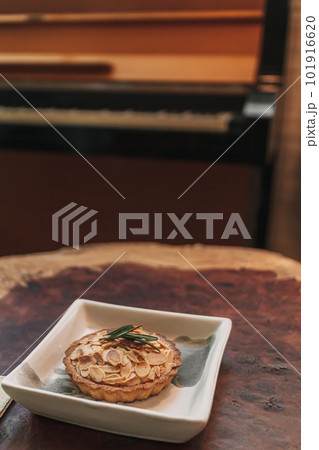 Closeup of small tart almond slice served on wooden table. Closeup of small tart almond slice served on wooden table. 101916620