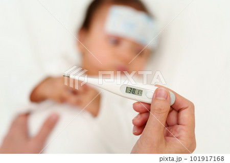 mother measuring temperature of sick baby with cool fever jel pad. displey high fever temperature 101917168