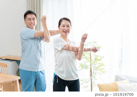 家で運動するシニア夫婦(肩のストレッチ) 家で運動するシニア夫婦(肩のストレッチ) 101919700