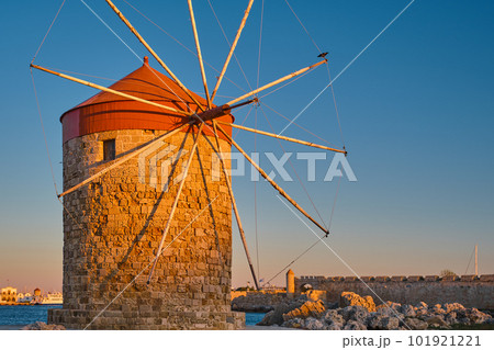 Old windmill on the bay during sunset, in the city of Rhodes on the island of Rhodes of the island of the Dodecanese archipelago, vacation in Europe and a popular tourist destination Old windmill on the bay during sunset, in the city of Rhodes on the island of Rhodes of the island of the Dodecanese archipelago, vacation in Europe and a popular tourist destination 101921221