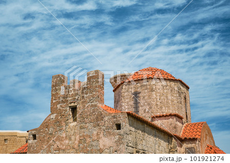 Church of the Holy Trinity against background of sky with clouds, streets in the old center of Rhodes, Greek islands of the Dodecanese archipelago, holidays in Europe and a popular tourist destination 101921274