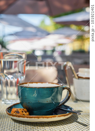 Vertical shot, a cup of espresso coffee, a glass of water and cookies on the table, coffee break time. Close-up, sunlight and selective focus, empty space, idea for advertising or banner Vertical shot, a cup of espresso coffee, a glass of water and cookies on the table, coffee break time. Close-up, sunlight and selective focus, empty space, idea for advertising or banner 101921401