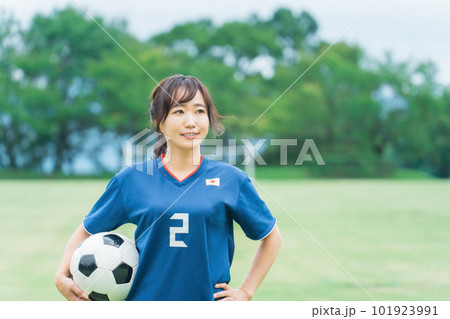 サッカーボールを持ちながら笑顔でサッカーするファン・サポーターの日本人女性 101923991
