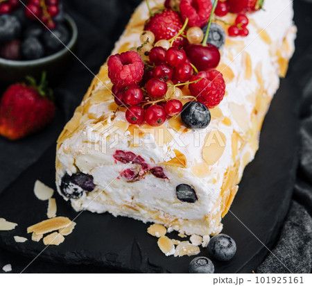 Meringue roll with cream and berries and almonds Meringue roll with cream and berries and almonds 101925161