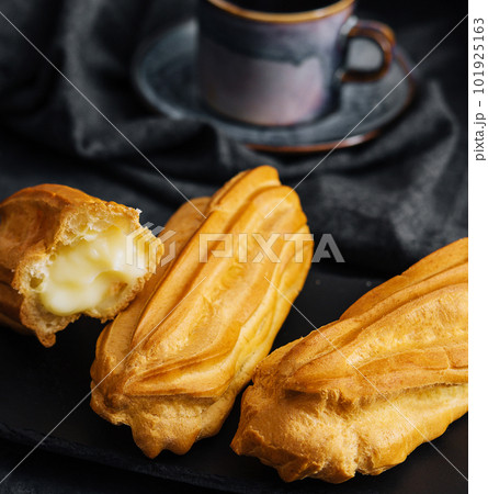 Eclairs with cream on stone board 101925163