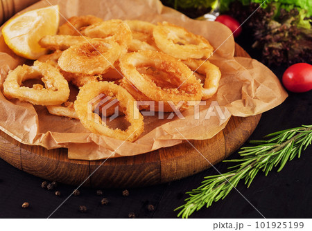 Oven baked breaded calamari rings served with lemon 101925199