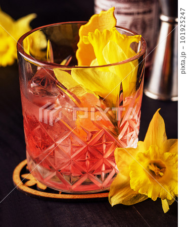 Glass of negroni cocktail decorated with flowers 101925247