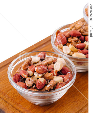 Assorted nuts in a glass bowls on wooden Assorted nuts in a glass bowls on wooden 101926362