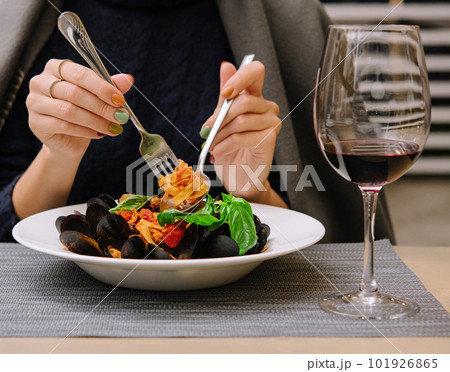 beautiful woman eating pasta with mussels in a restaurant 101926865